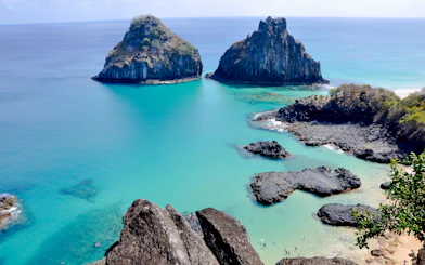 Turquoise waters and rocky formations at Sancho Beach, Noronha, Brazil.