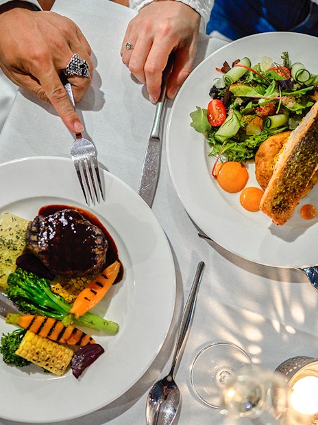 Dining on the Spirit of Melbourne Dinner Cruise with gourmet dishes and wine.
