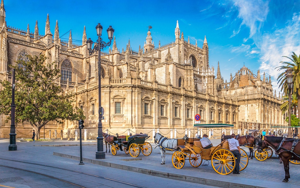 Horse-drawn carriages in front of Seville Cathedral, Spain.