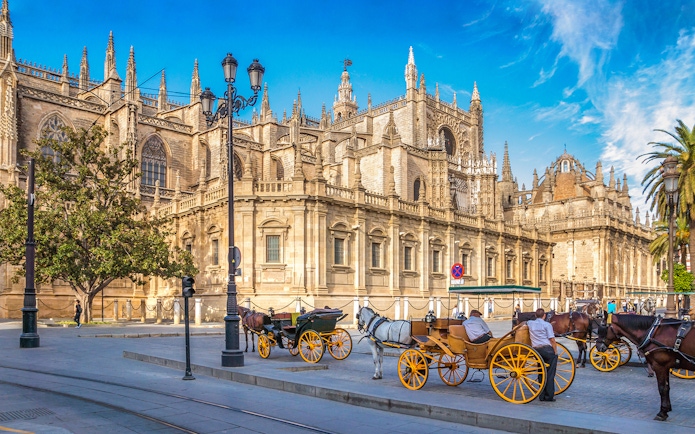 Horse-drawn carriages in front of Seville Cathedral, Spain.