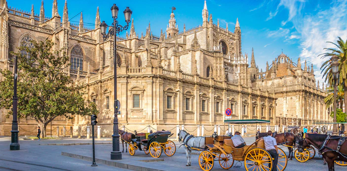 Horse-drawn carriages in front of Seville Cathedral, Spain.