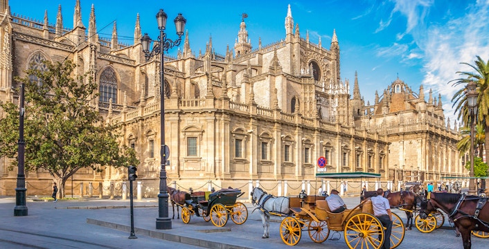 Horse-drawn carriages in front of Seville Cathedral, Spain.