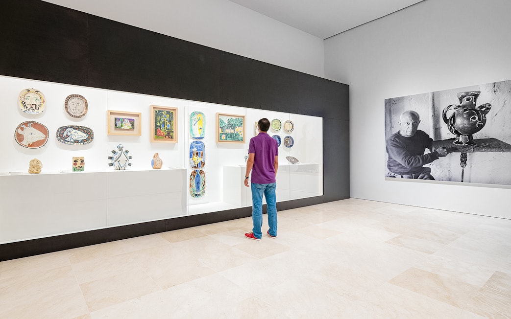 Visitor viewing Picasso ceramics and paintings at Picasso Museum Malaga.