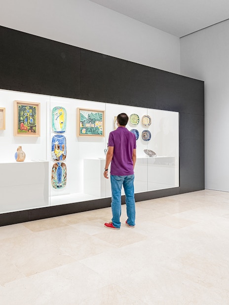 Visitor viewing Picasso ceramics and paintings at Picasso Museum Malaga.