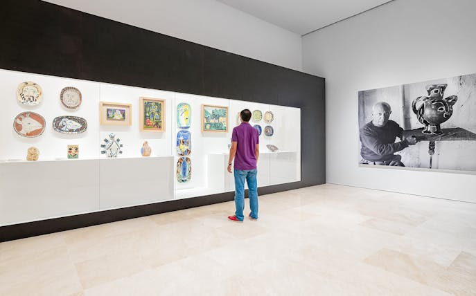 Visitor viewing Picasso ceramics and paintings at Picasso Museum Malaga.