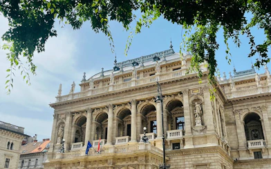 Hungarian State Opera House facade with statues and flags, Budapest.
