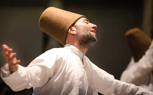 Whirling Dervish performing in traditional attire during a ceremony in Istanbul.