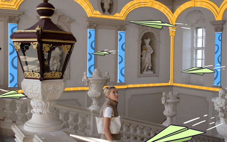 Visitor admiring ornate architecture in a historic building with statues and decorative columns.