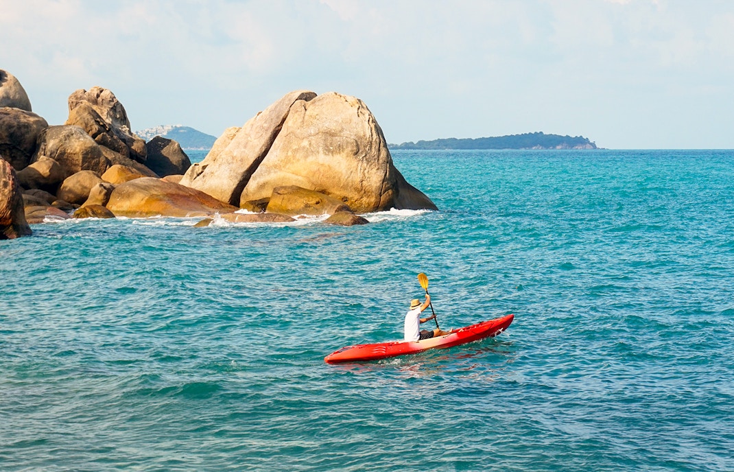Kayakers paddling near Cape Otway lighthouse, Australia, with scenic coastal views.