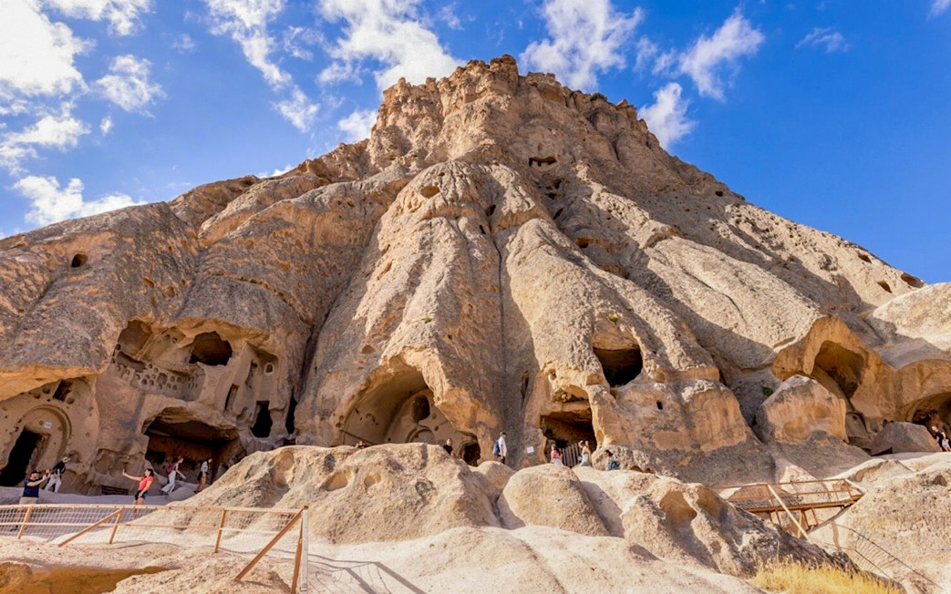 Selime Monastery rock formations with visitors in Cappadocia, Turkey.