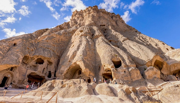 Selime Monastery rock formations with visitors in Cappadocia, Turkey.