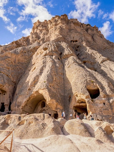 Selime Monastery rock formations with visitors in Cappadocia, Turkey.