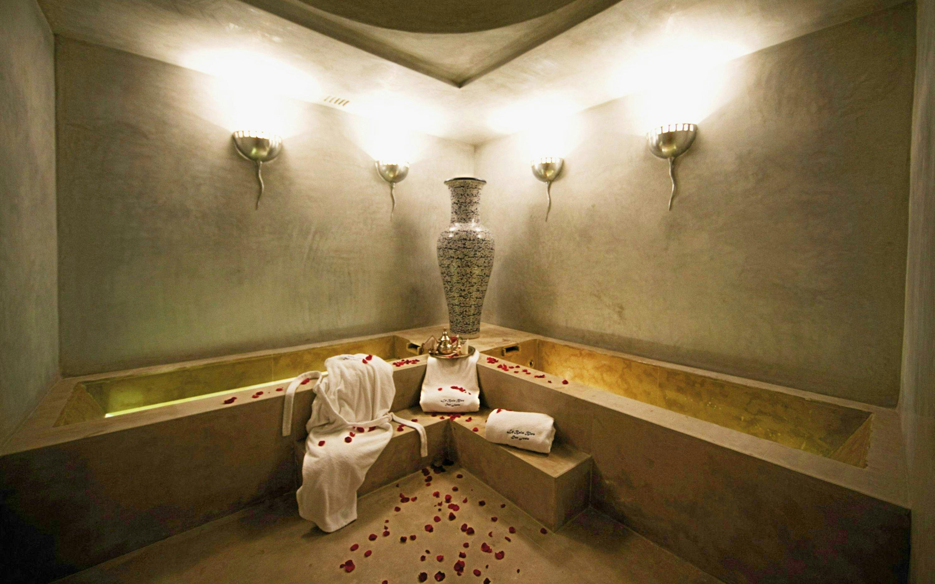Le Bain Bleu Hammam & Spa interior with rose petals and towels, Marrakesh.