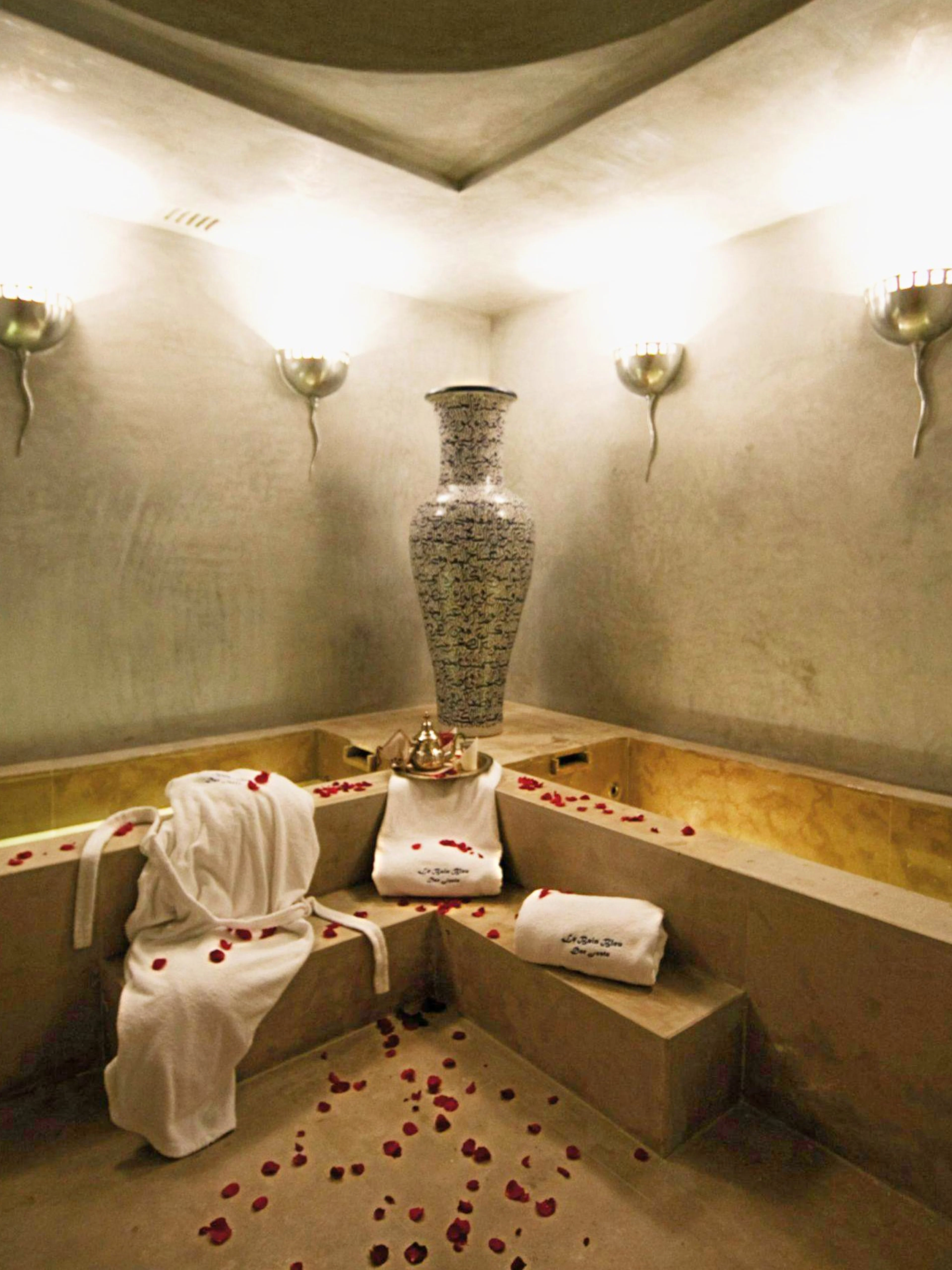 Le Bain Bleu Hammam & Spa interior with rose petals and towels, Marrakesh.