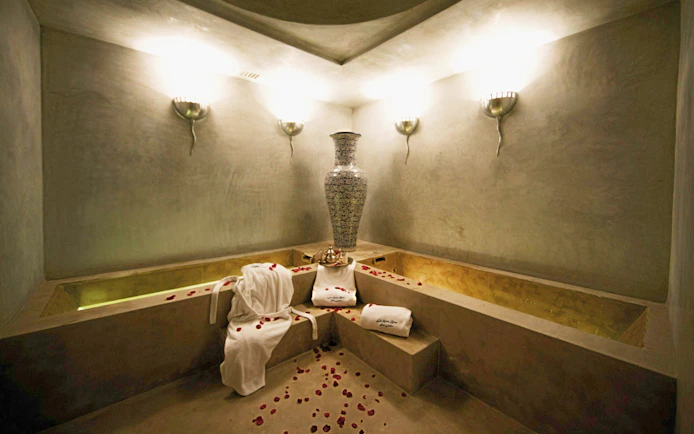 Le Bain Bleu Hammam & Spa interior with rose petals and towels, Marrakesh.