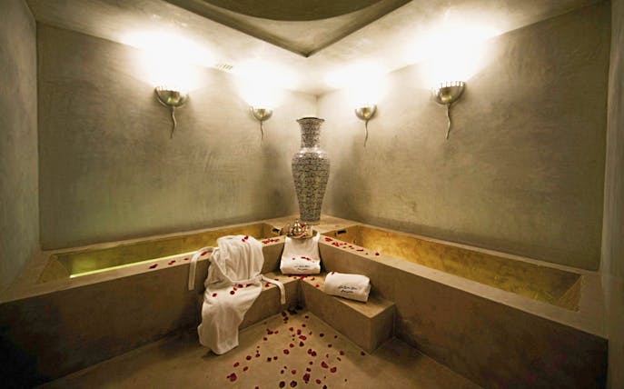 Le Bain Bleu Hammam & Spa interior with rose petals and towels, Marrakesh.