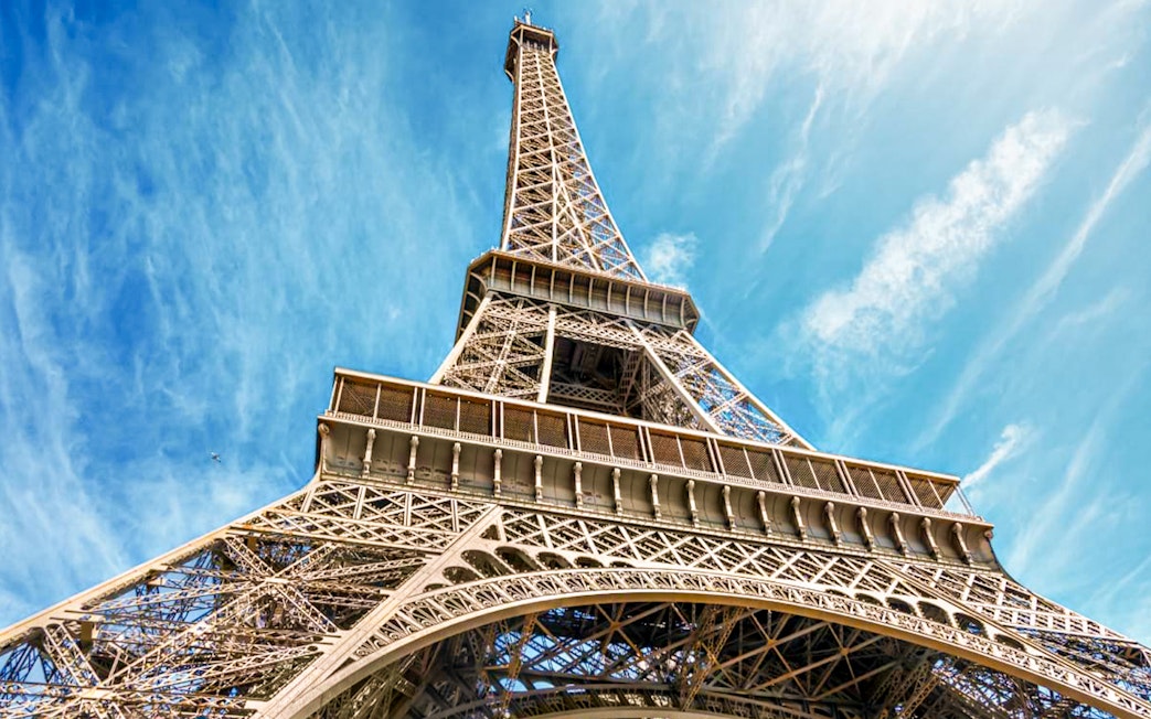 Eiffel Tower viewed from below against a blue sky in Paris, France.