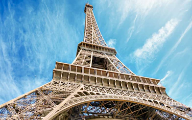 Eiffel Tower viewed from below against a blue sky in Paris, France.