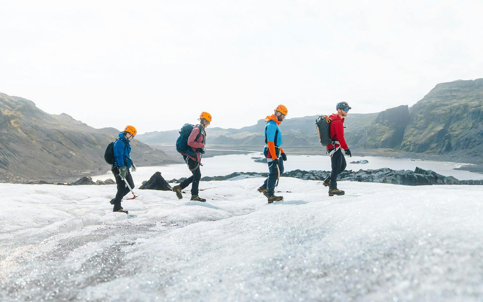 Guests hiking on Solheimajökill Glacier in Iceland with scenic mountain views.