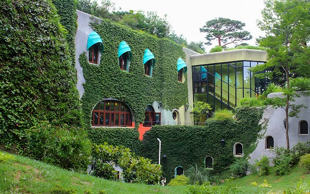 Studio Ghibli Museum exterior with ivy-covered walls and colorful windows in Mitaka, Japan.