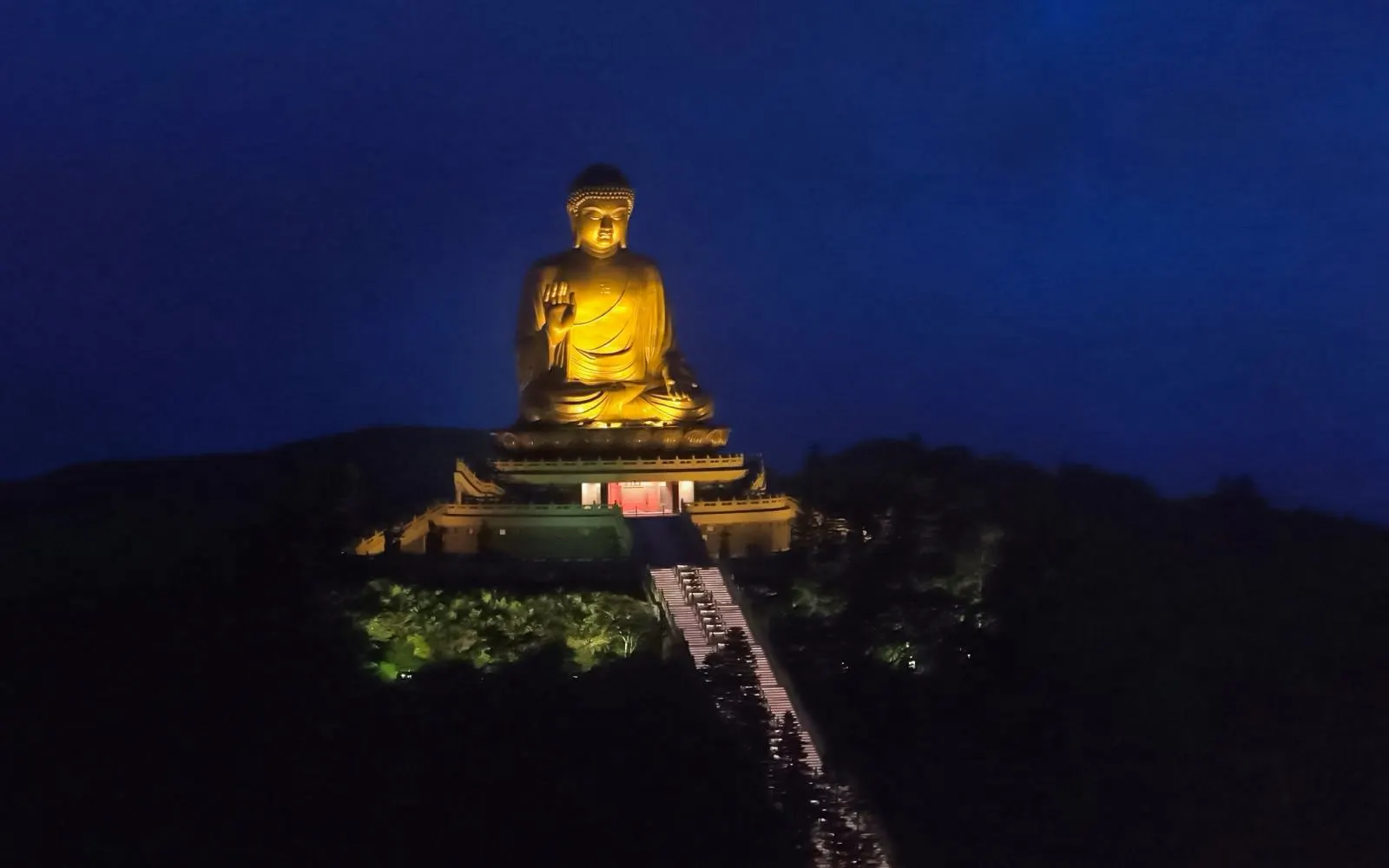 Buddha statue illuminated at night, viewable from Ngong Ping 360 cable car, Lantau Island.