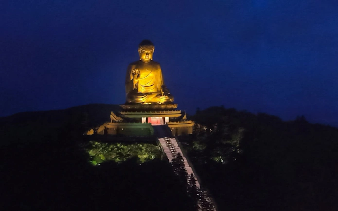 Buddha statue illuminated at night, viewable from Ngong Ping 360 cable car, Lantau Island.