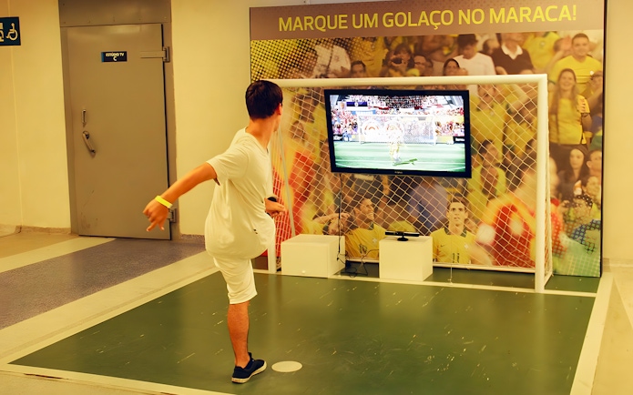 Person playing virtual soccer game in the game zone area of Maracanã Stadium, Brazil.
