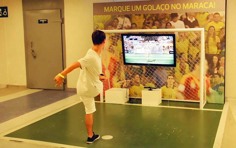 Person playing virtual soccer game in the game zone area of Maracanã Stadium, Brazil.
