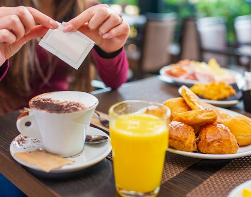 Cappuccino with pastries and orange juice at a cafe table.