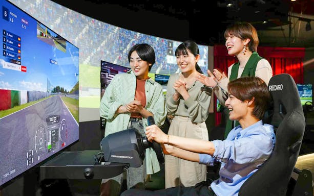 Friends enjoying a racing simulator at RED° TOKYO TOWER.