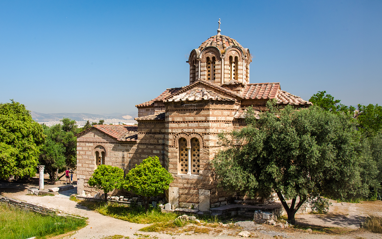 Church of the Holy Apostles in Athens surrounded by trees and ancient ruins.