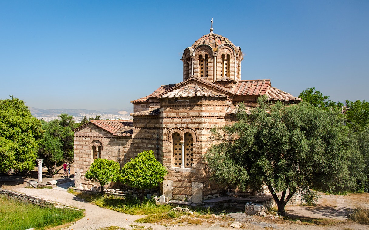 Church of the Holy Apostles in Athens surrounded by trees and ancient ruins.