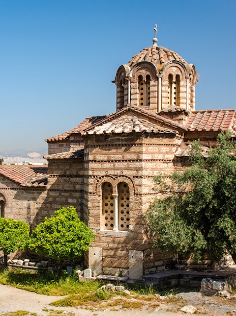 Church of the Holy Apostles in Athens surrounded by trees and ancient ruins.