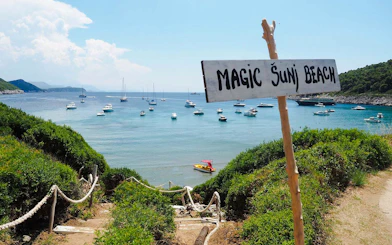 Pathway leading to Šunj Beach with boats anchored in the bay, Lopud Island, Croatia.
