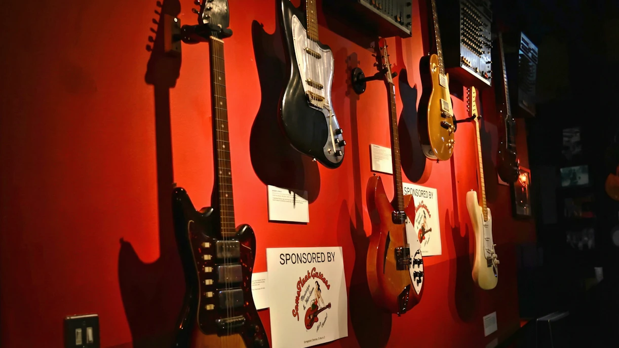 Guitars displayed on a red wall at the Irish Rock N Roll Museum Experience.