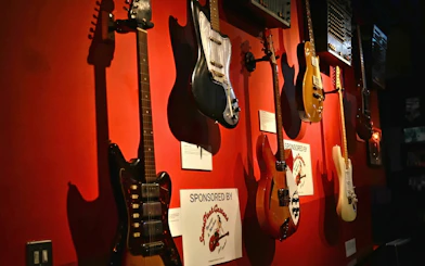Guitars displayed on a red wall at the Irish Rock N Roll Museum Experience.