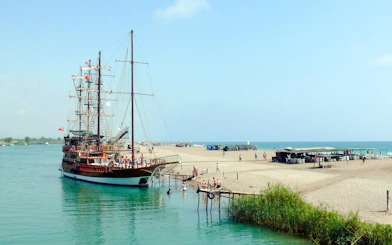 Cruise ship docked at sandy beach during Manavgat River to Dolphin Island tour.