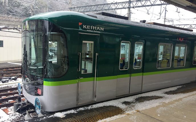 Keihan train at snowy Kyoto station platform for sightseeing tour.