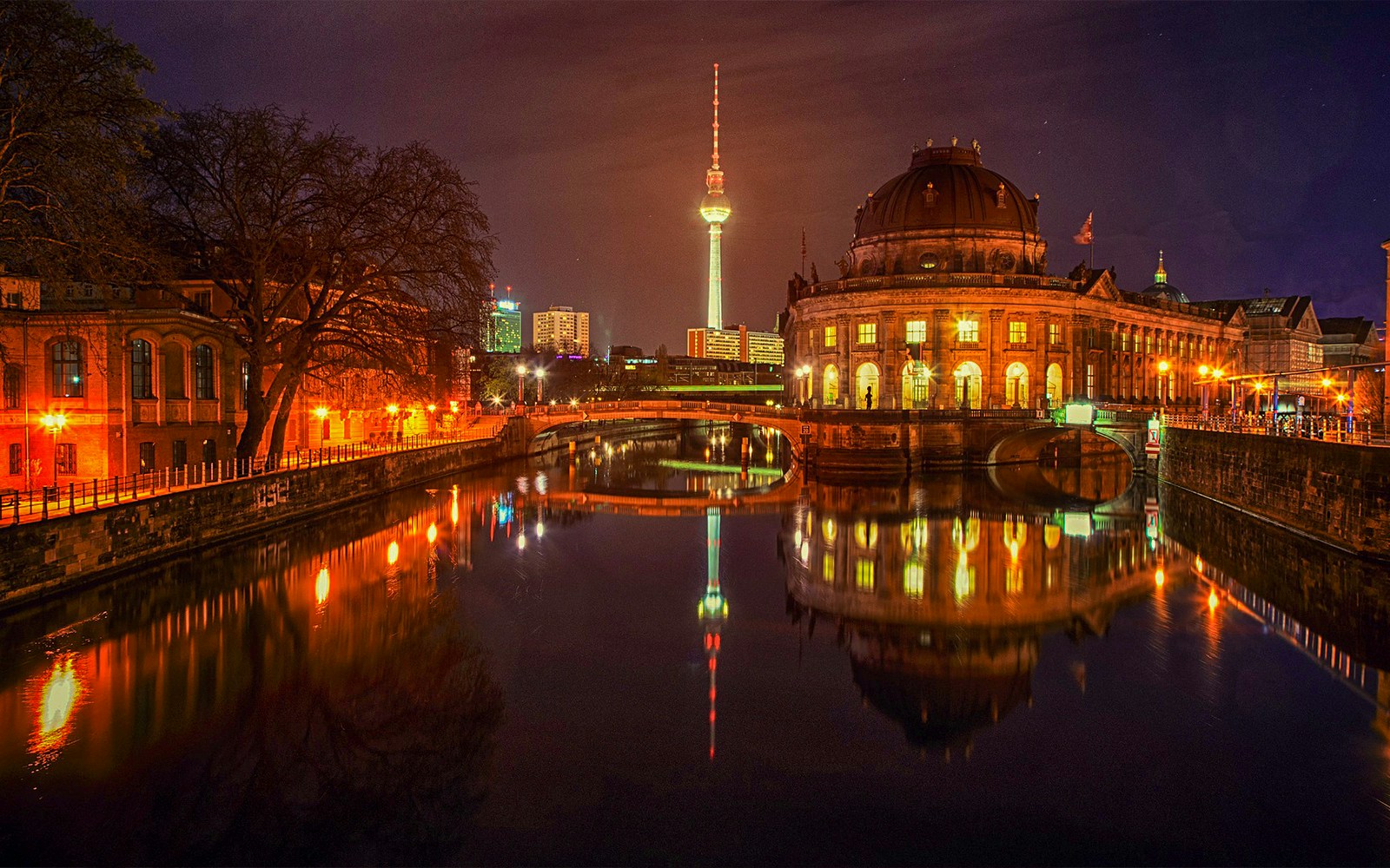 Berlin evening sightseeing cruise on the Spree River with illuminated cityscape.