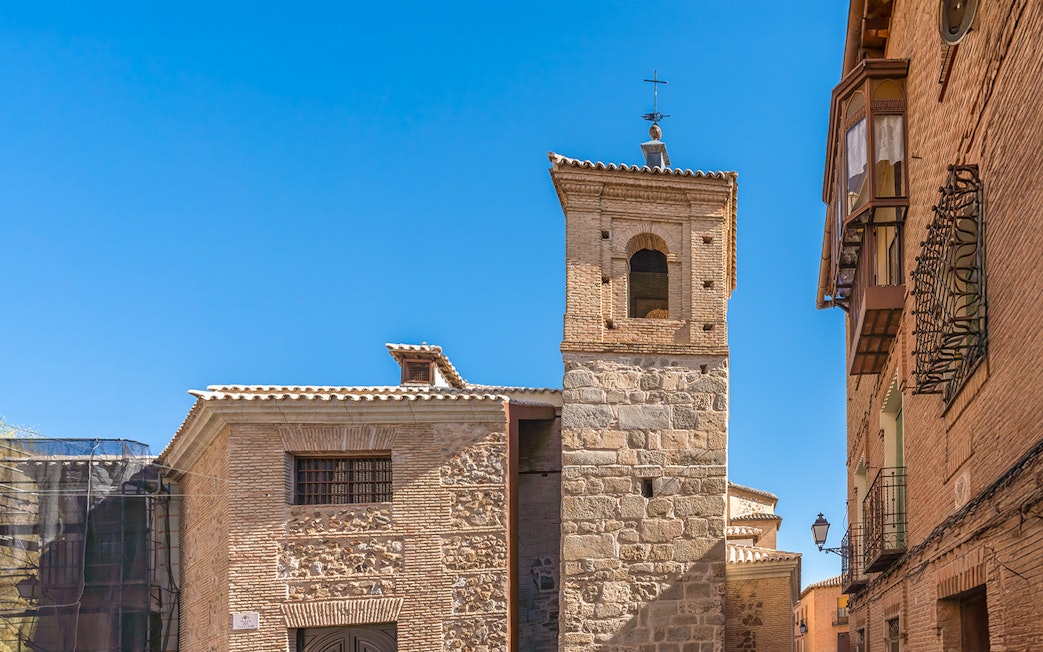 El Salvador Church tower in Toledo, Spain, with stone and brick architecture.