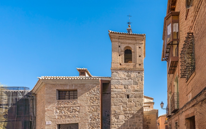 El Salvador Church tower in Toledo, Spain, with stone and brick architecture.