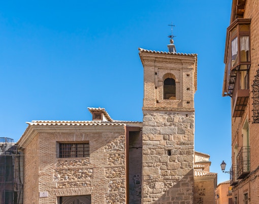 El Salvador Church tower in Toledo, Spain, with stone and brick architecture.