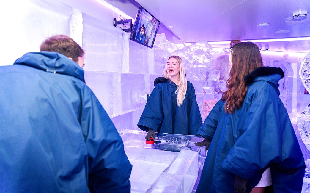 Visitors enjoying games at IceBar Surfers Paradise, surrounded by ice sculptures.