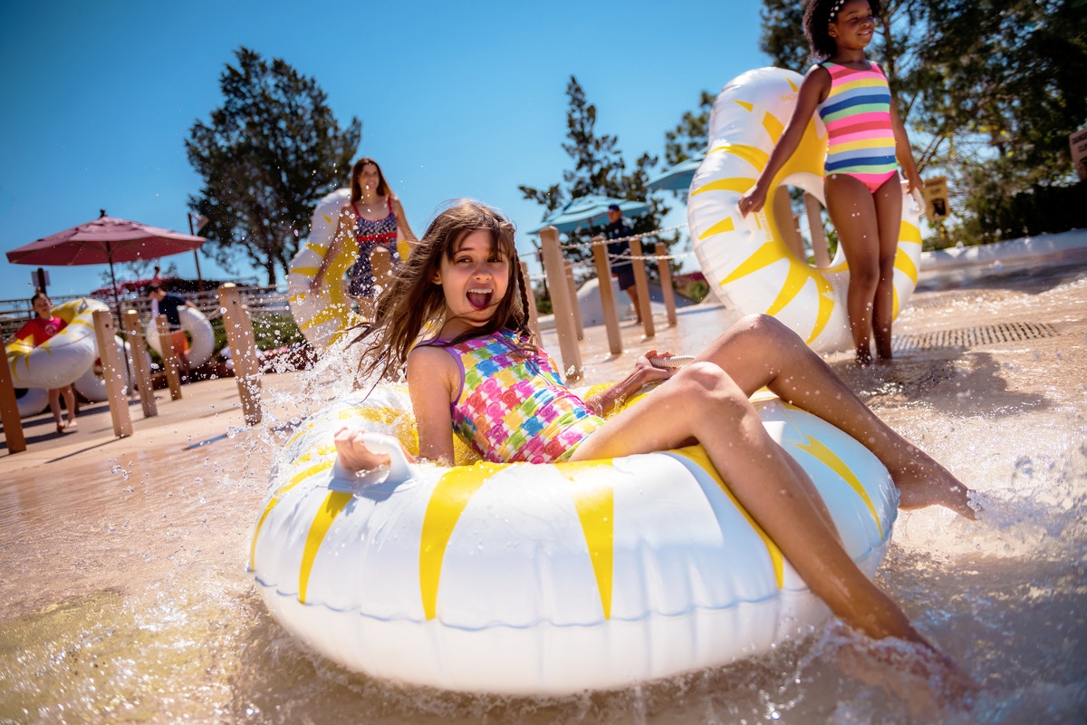 Girl enjoying water slide on tube at Walt Disney World Resort, Orlando.