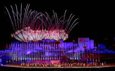 Spectacular night show with fireworks at Puy du Fou España, featuring illuminated castle and performers.