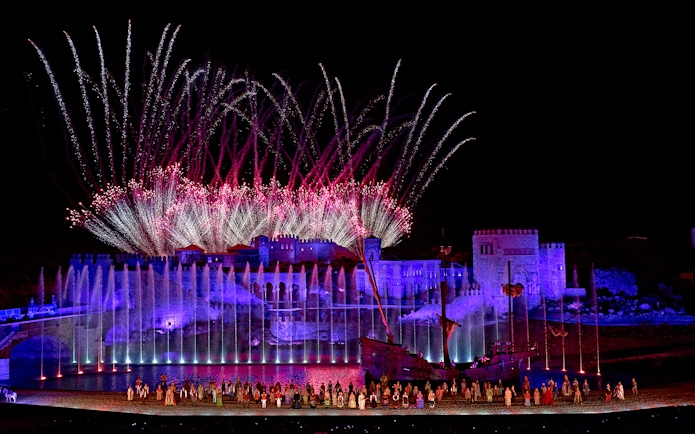 Spectacular night show with fireworks at Puy du Fou España, featuring illuminated castle and performers.