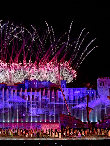 Spectacular night show with fireworks at Puy du Fou España, featuring illuminated castle and performers.