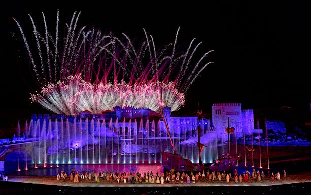 Spectacular night show with fireworks at Puy du Fou España, featuring illuminated castle and performers.
