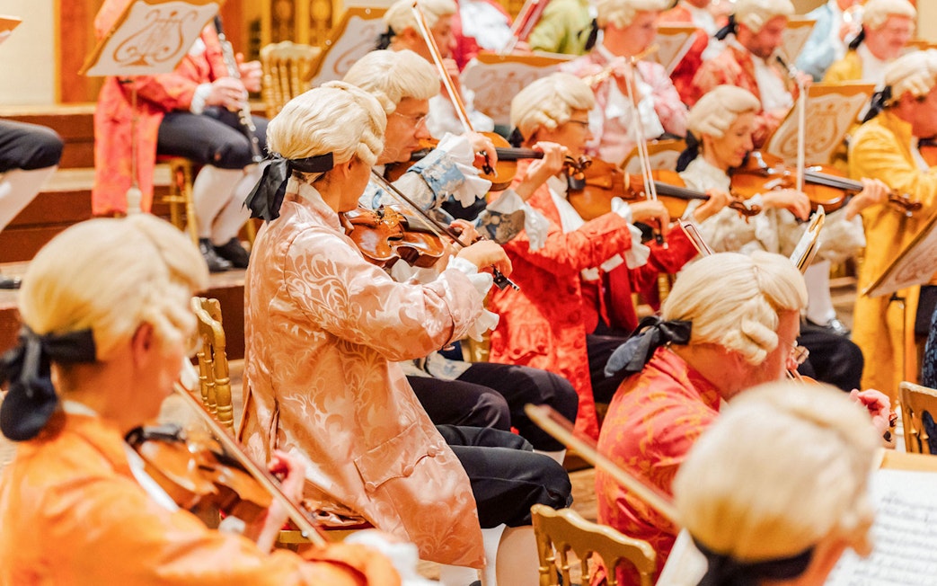 Orchestra in period costumes performing at Vienna's Musikverein Golden Hall.