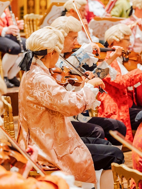 Orchestra in period costumes performing at Vienna's Musikverein Golden Hall.